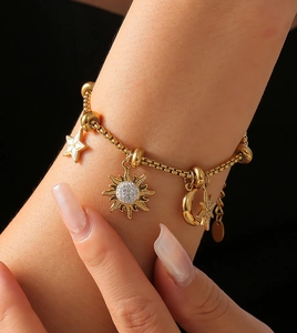 Detailed view of 18k gold plated bracelet with celestial sun moon and star charms