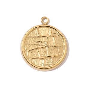 Macro shot of a vintage gold-plated round charm with irregular cracked texture