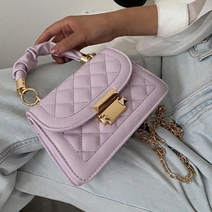 Detailed close-up of light purple quilted PU leather handbag with gold chain strap