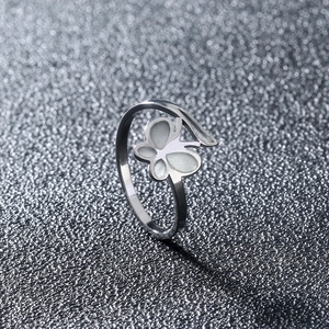 Macro detail of polished stainless steel butterfly ring with white inlaid mother of pearl