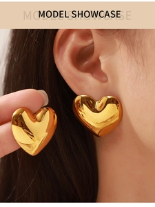 Nahaufnahme eines großen goldenen Herzohrrings mit glatt polierter Oberfläche und Glanz