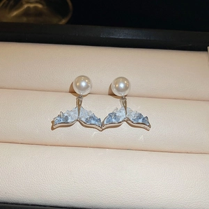Détail de boucles d'oreilles queue de poisson avec cristaux bleus et perles