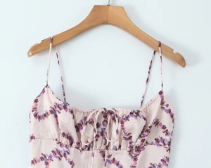 Detail of floral spaghetti strap dress with drawstring ruched bust on wooden hanger