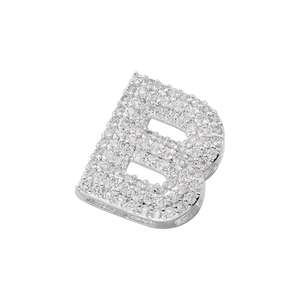 Macro shot of silver pendant shaped like letter B encrusted with sparkling cubic zirconia