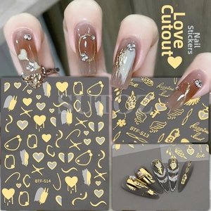 Macro detail of laser rose gold heart and wing nail stickers on a manicure