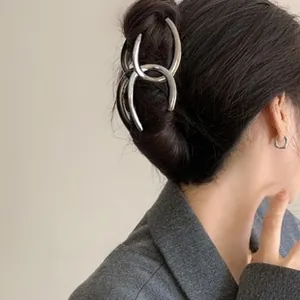 Detail view of large silver metal hair claw clip in a minimalist double-ring design