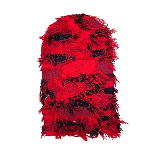 Detail of red and black knit balaclava with punk style distressed fringe and textures