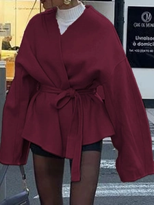 Détail d'un manteau portefeuille bordeaux avec manches évasées et ceinture nouée