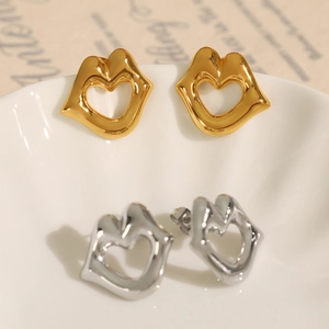 Polished gold and silver hollow lip earrings on a white shell plate for women