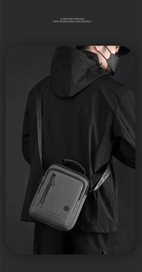 Détail du sac à bandoulière gris avec sangle en nylon et poches zippées multiples