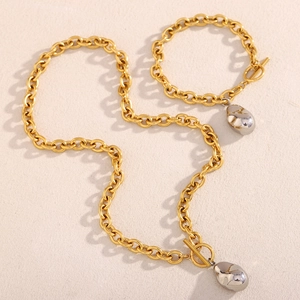 Dettaglio del set di collana e bracciale bicolore oro e argento con maglia a forma di arachide