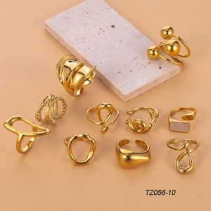 Set of 10 vintage geometric gold-plated stainless steel rings displayed on a stone