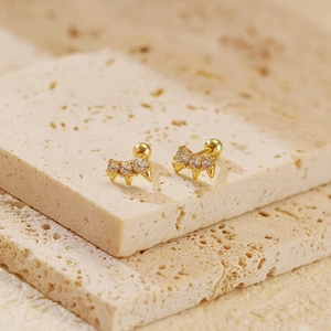 Macro shot of gold S925 silver stud earrings with three sparkling zircon stones