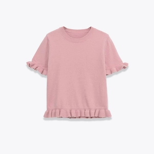 Pink short sleeve knit sweater with ruffled hem and round neck on grey background