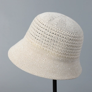 Detailed close-up of breathable hollow-out knitting pattern on cream crochet sun hat