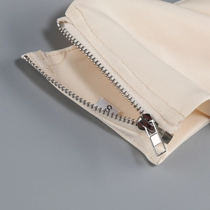 Detail of metal zipper and woven fabric texture on the off-shoulder fishtail dress