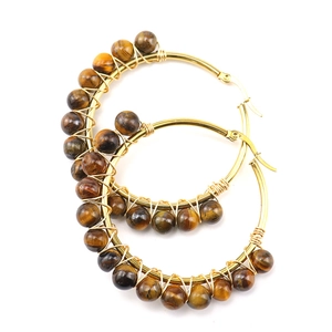 Detail of tiger eye stones wrapped on gold stainless steel hoop earrings