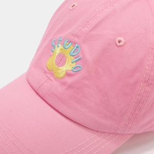 Close-up of yellow sunflower and studio embroidery on pink cotton baseball cap