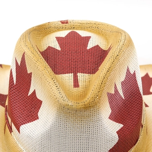 Close-up of woven straw cowboy hat featuring a printed red maple leaf design