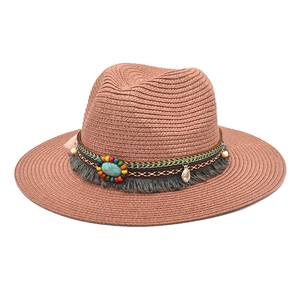 Detail of woven straw fedora featuring bohemian beads, turquoise stone and grey fringe