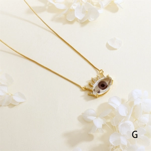 Close-up of gold-plated evil eye pendant with zircon inlay and sun-shaped details