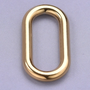 Detailed view of an oval 304 stainless steel golden ring accessory on purple fabric