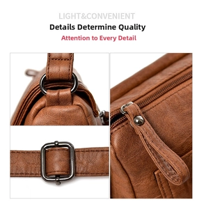 Detail view of brown pebbled leather bag with metal D-rings and studded zipper puller