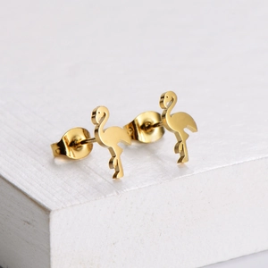 Polished gold flamingo stud earrings made of titanium steel displayed on a white podium