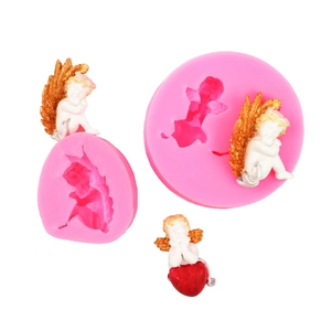 Pink silicone angel wing molds with finished 3D baby angel cake toppers and gold wings