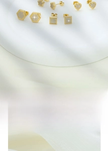Macro shot of gold-plated square and star earrings set with sparkling cubic zirconia