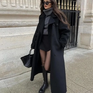 Détail d'un manteau noir en laine avec double boutonnage et col à revers classique chic