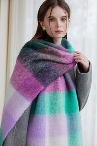 Close-up of thick winter scarf with purple, green, grey, and white patchwork pattern