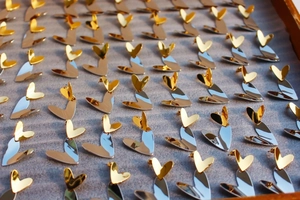 Detailed close-up of mixed gold and silver heart-shaped earrings on velvet display tray