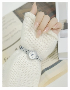 Close-up of elegant GEDI silver metal bracelet watch worn over a white knit sweater