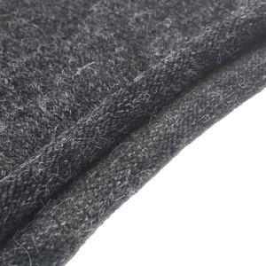 Macro shot of dark grey wool fabric showing thick knitted texture and soft fiber fluff