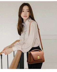 Classic brown leather shoulder bag featuring a gold metal clasp and adjustable strap