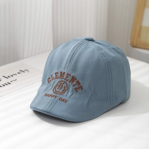 Détail du béret bleu en coton pour enfant avec texte Clemente et broderie smiley joyeux