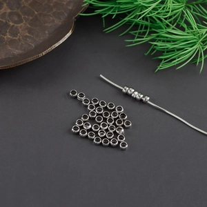 Detail view of silver-plated positioning beads for DIY jewelry making on a metal wire
