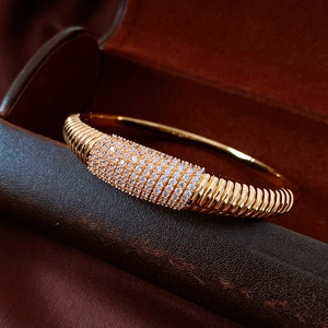 Dettaglio del bracciale a righe placcato oro con zirconi su scatola porta gioielli