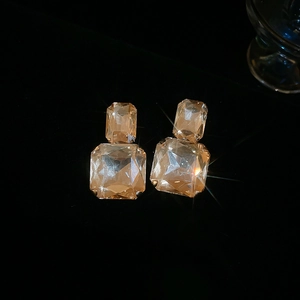 Detail of champagne square crystal earrings with double layered faceted stones on black