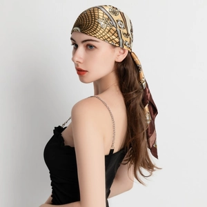 Detail of silk scarf featuring paisley baroque patterns in brown and gold tones