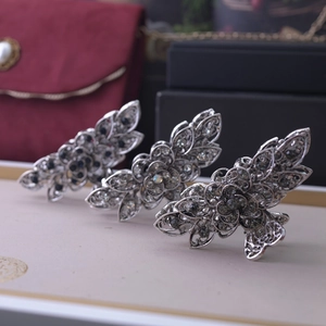 Three silver floral hair claws with dark rhinestones displayed in premium gift setting