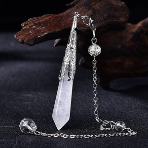 Detailed view of natural quartz crystal pendant with vintage silver filigree cap and chain