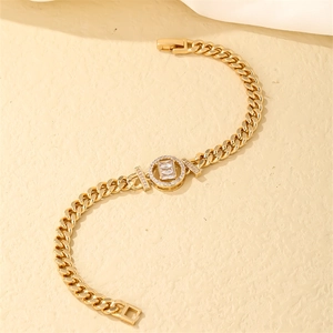 Detailed macro view of a gold Cuban chain bracelet with a rectangular zircon pendant