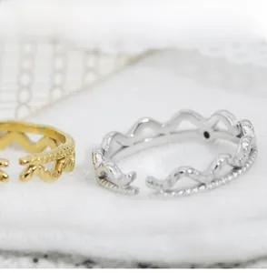 Detailed view of adjustable wavy stacking rings with silver and gold plating