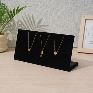Close-up of black velvet L-shaped jewelry display stand with gold necklaces