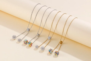 Detail of multiple gold and silver stainless steel necklaces with sparkling crystal ball charms