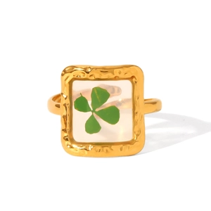 Detail of 18K gold stainless steel ring with a real four-leaf clover in square resin