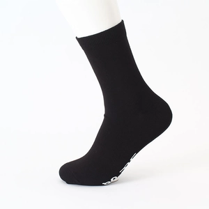 Detail of black cotton crew sock featuring white anti-slip lettering on the sole
