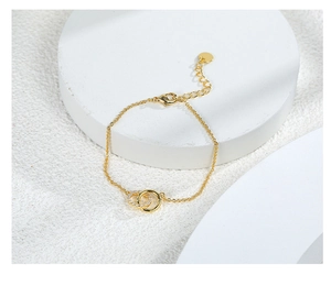 Detail of gold-plated double interlocking rings bracelet with sparkling cubic zirconia